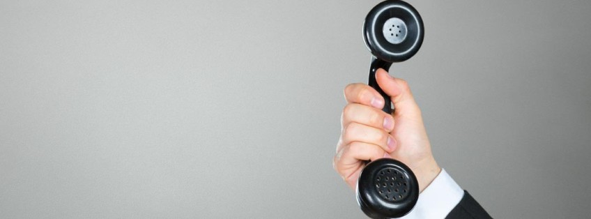 close up of a man holding a telephone