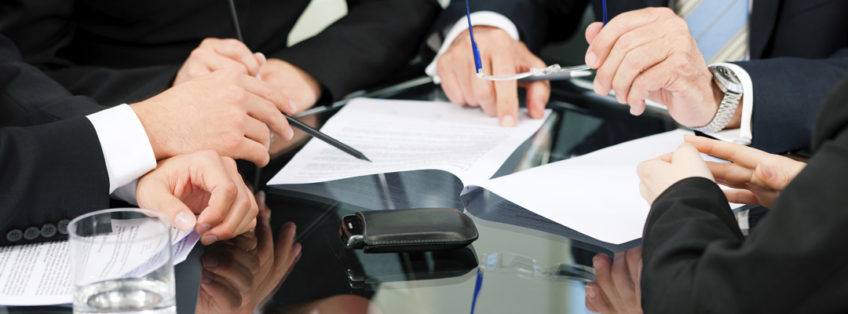 business people in a meeting sat around a table