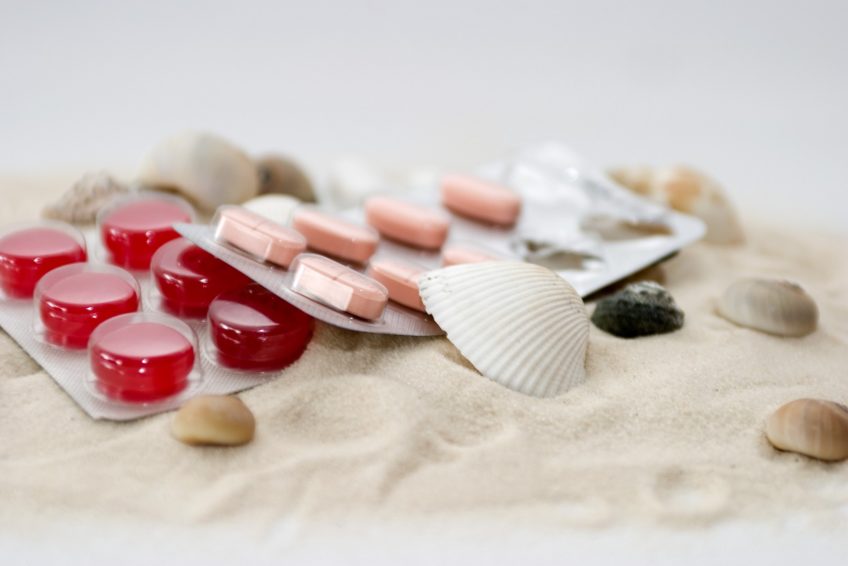 tablet blisters sitting in sand with shells