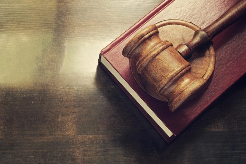 Gavel and legal book on wooden table