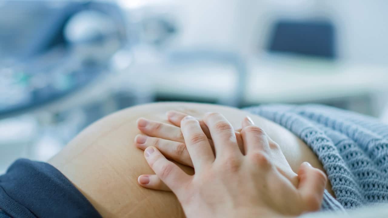 Close-up on the Pregnant Woman's Belly, She and Her Husband Carefully touch it, Trying to Feel if Baby kicks.