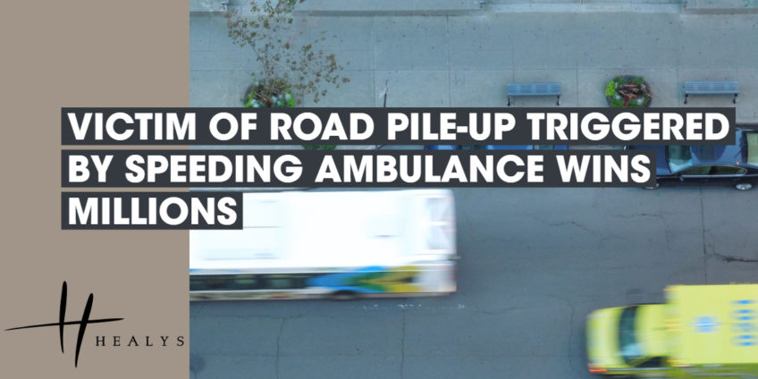 ambulance driving down a road past a bus and car