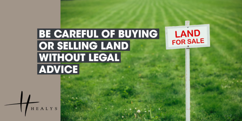 field with a sign which reads land for sale