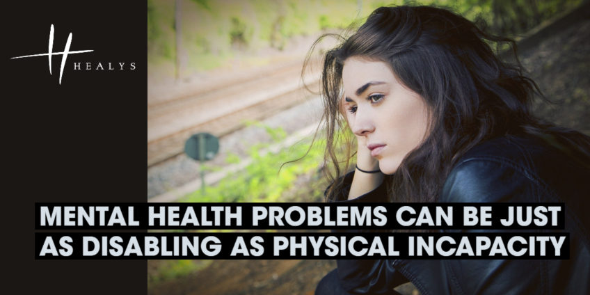 Young woman sitting by railway tracks looking troubled