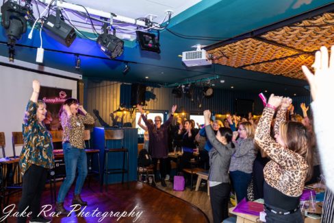 women engaging in the event workshop by raising their hands in the air