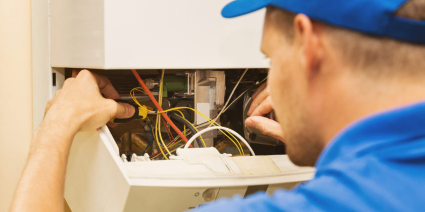 maintenance service engineer working with home gas heating boiler