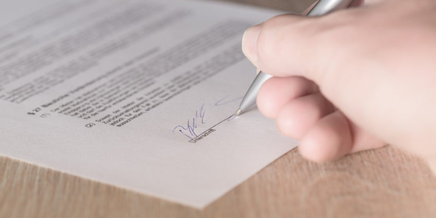 Close up of hand signing a contract