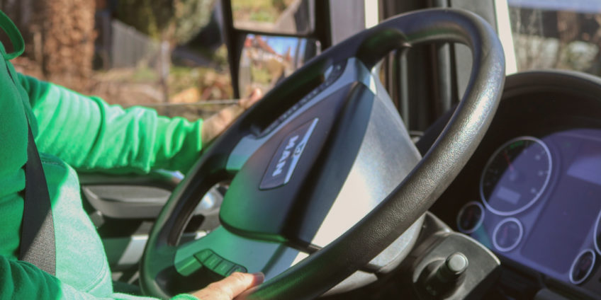 Man driving truck with hands on wheel