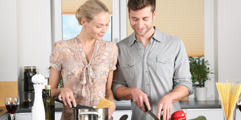 Couple cutting vegetables to prepare for cooking