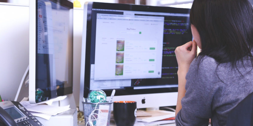 Woman working from home using two monitors