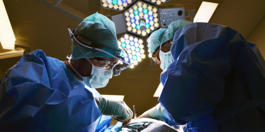 Surgeons operating on patient in theatre