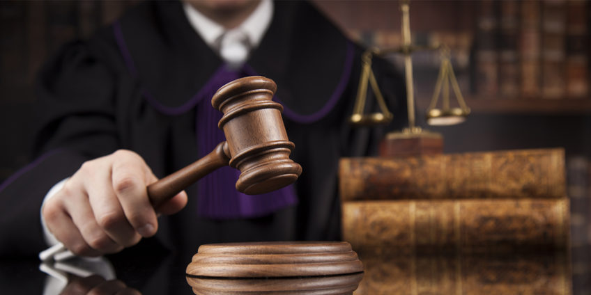 Male judge in courtroom striking the gavel