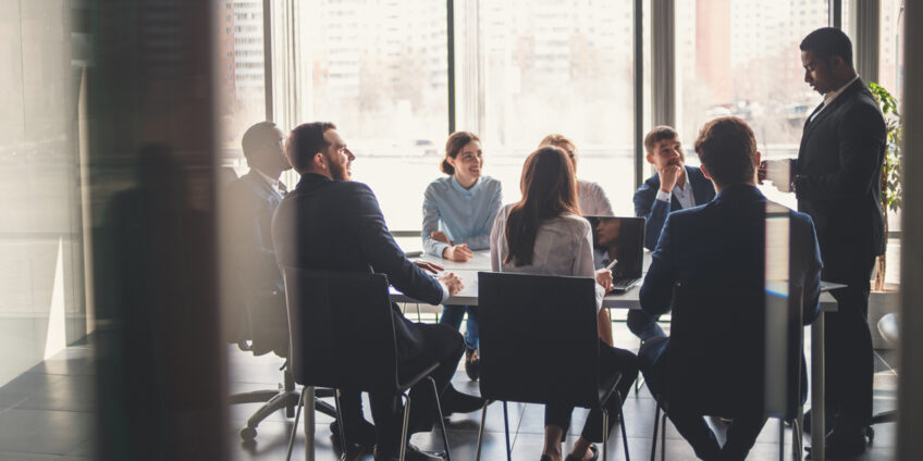 man presenting to rest of boardroom in a meeting