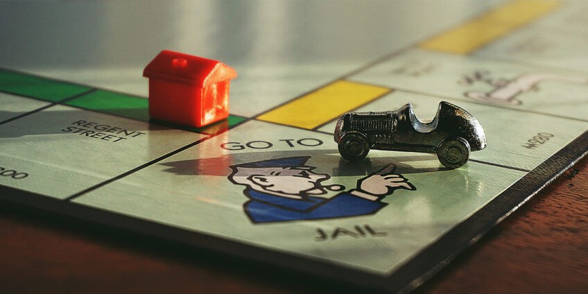 photo of a monopoly board, focused on the go to jail square, on which the car figure sits