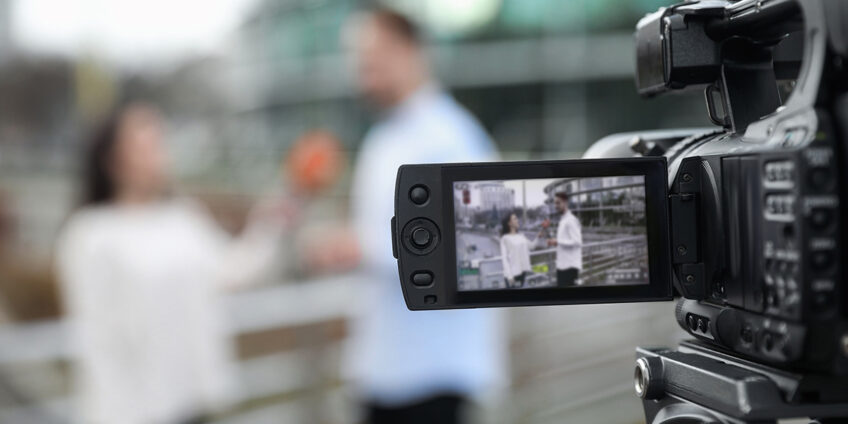 camera filming a female presenter interviewing a man